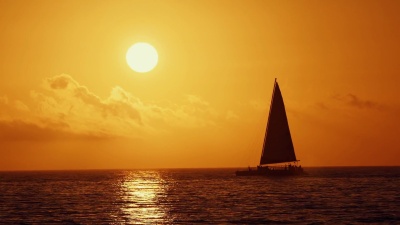 在金色夕阳下航行的航海船