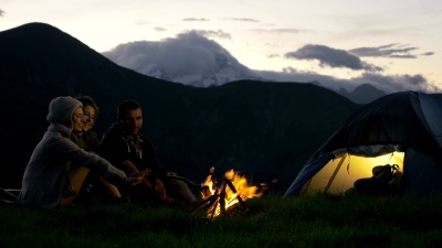 三个朋友一组在自然山上营火取暖夜间露营场景-高清视频片段