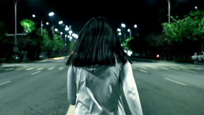 夜晚在城市街道上奔跑的女人