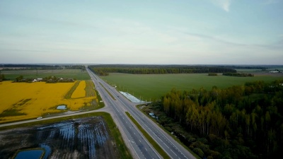 平原上有森林和油菜田的高速公路。空中无人驾驶飞机 旋转射击。农产品产业物流