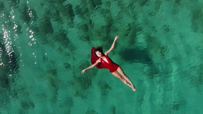 空中无人驾驶飞机在热带海面上漂浮和游泳的女人