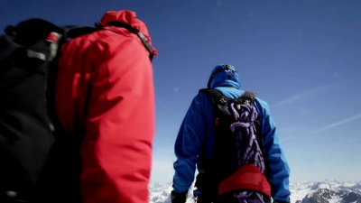 登山者在白雪覆盖的山峰上行走