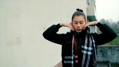 穿着黑色的性感女人，化妆在白色彩绘的砖墙上跳舞
