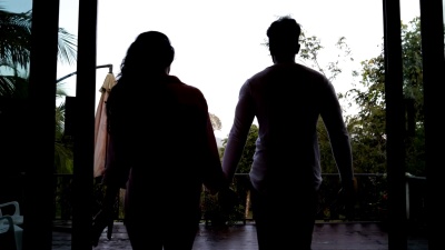 夏日阳台上跑车漫步的后视图牵着手混合种族男人和女人看早晨的热带雨林