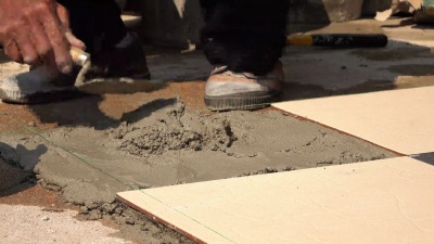 建筑工人使用腻子刀瓷砖地板