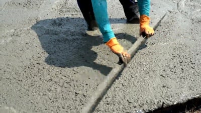 建筑工人正在用抹灰设备调整水泥地面的表面