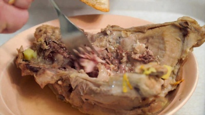一个男人用叉子从被吃掉的兔子尸体上收集肉