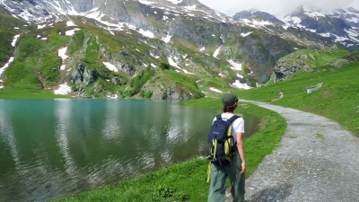 女人在阿尔卑斯山上的蓝湖徒步旅行