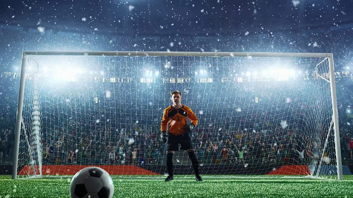 足球守门员在职业足球场上跳跃和接球。体育场和人群是以3D和动画制作的