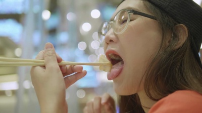 年轻快乐的亚洲女子享受美味的日本食物的特写镜头。