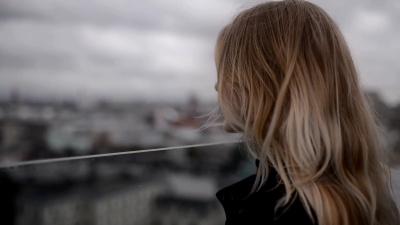 屋顶上的年轻女子看着地平线。