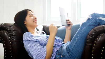 在家中使用数字平板电脑的年轻亚洲美女