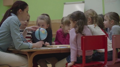   幼儿教师和儿童在课堂上学习地理。
