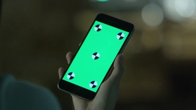 傍晚时分，小女孩抱着带着绿屏的菲尔布莱特(Phablet With Green Screen)。休闲的生活方式。