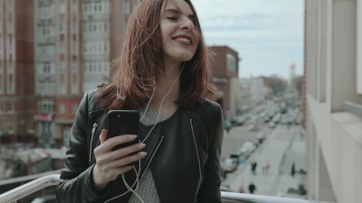 摇滚风格的女人在城市里听音乐跳舞