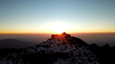 日出时肯尼亚山Lenana山顶上无法辨认的登山者的鸟瞰