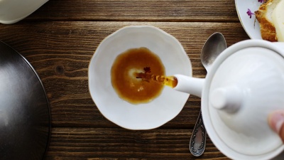 茶壶里的茶慢慢倒进瓷杯里