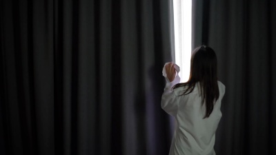 女人早上拉开窗帘