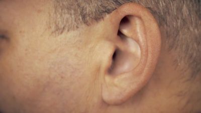 男人左耳。男性耳朵的宏观极端特写。概念为音频音乐，声音健康，人耳。