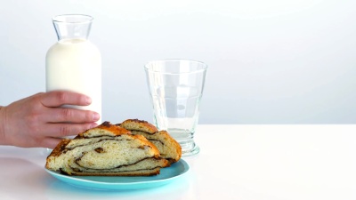 牛奶装满了杯子。盘子上是一片片的滚子