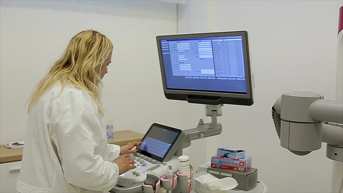 放射科医生正在用一台现代的3D超音波扫描仪进行扫描