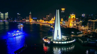 黄浦江上的内河船与夜间浦西北部天际线的背景