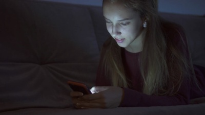 微笑的女孩晚上在床上发短信