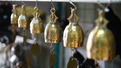 泰国女游客在纪念品商店挑选铃铛。