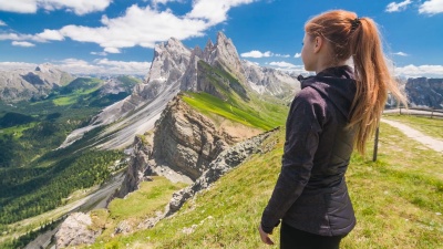年轻女性徒步旅行者从白云山的塞达山顶欣赏令人叹为观止的景色，对着镜头微笑