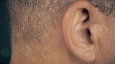 成年人听音乐。男人的右耳。男性耳朵的宏观极端特写。概念为音频音乐，声音健康，人耳。