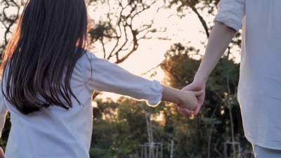 快乐的家庭在夏天散步。女人在日落时分和她可爱的小女儿在户外度过时光。重新养育孩子