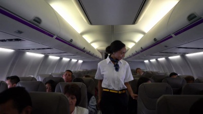 美丽的黑色空服员在起飞前检查每个人系安全带