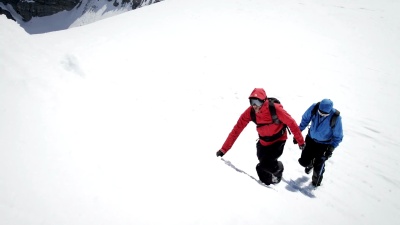 登山者在白雪覆盖的山上攀登