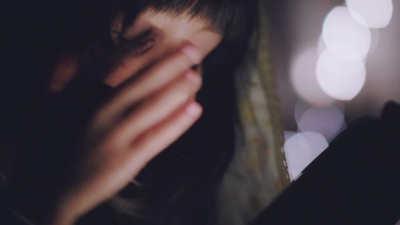 小女孩晚上在卧室里使用手机。