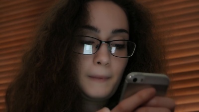 电话留言年轻女子，屏幕反射。