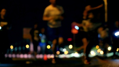 夜间城市跑步，带LED灯的人群跑步者，午夜跑步，每年夏季举行的短跑马拉松比赛，模糊中的无法辨认的人