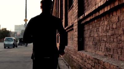 实时运动员在一条古老的街道上跑得很快。年轻、自由、坚定的专业男性健身教练。后视图