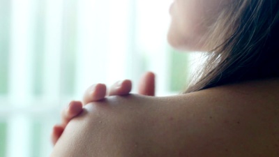 年轻女子轻轻抚摸她的皮肤，合上