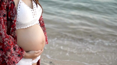 孕妇站在海边的海滩上。