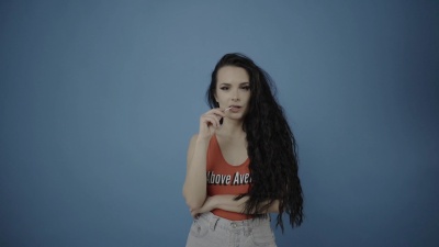 一位美丽的年轻女子在演播室里摆姿势，打电话或使用平板电脑设备，假装与男友或朋友交流