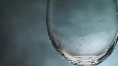 在黑暗的背景下倒一杯红酒。