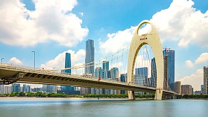 广州广州塔附近的现代桥在蓝云的天空中。时间延迟/中国广州。