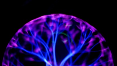 在黑色背景下带有移动能量射线的等离子球。特写视图