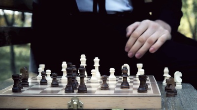 穿西装的男子在秋天公园下棋