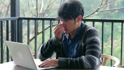 在咖啡馆里，男人在笔记本电脑前感到压力