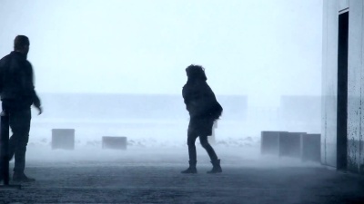 冰岛雷克雅未克，暴风雪肆虐，男人和女人在建筑物外