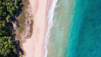 鸟瞰海浪撞击热带白沙海岸线