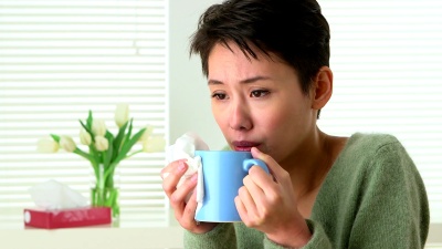 患流感的妇女打喷嚏和喝茶