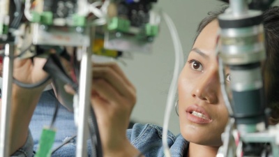 女电子工程师在实验室建造，测试，修理机器人。具有技术或创新概念的人。