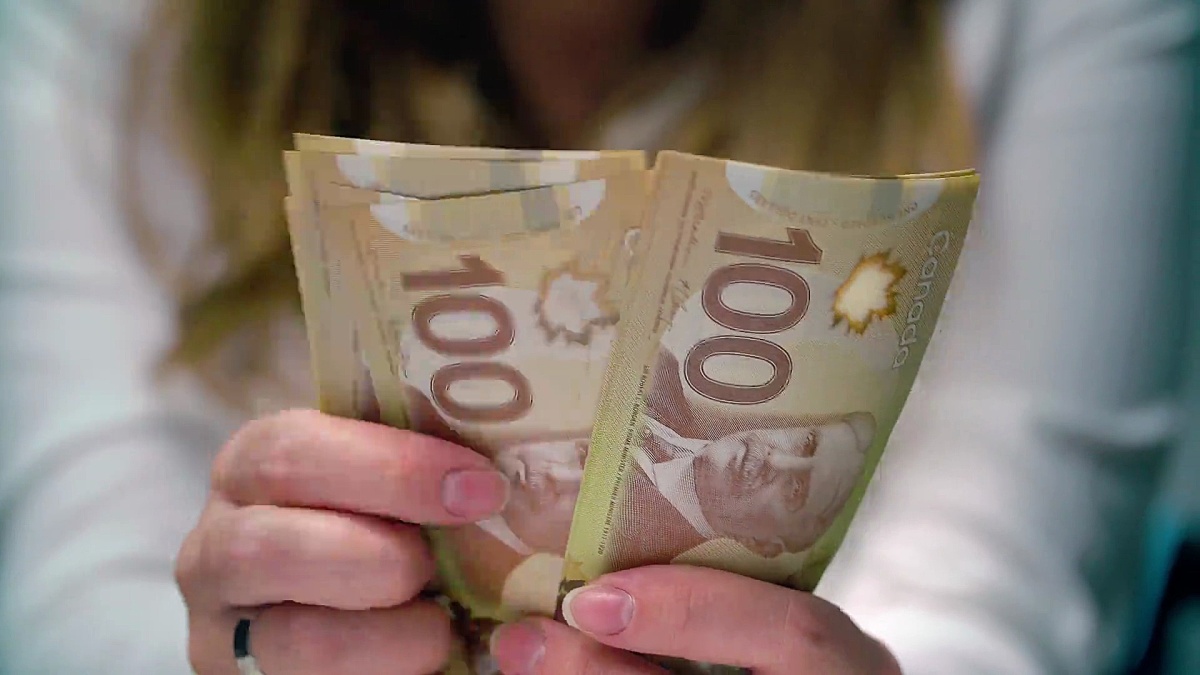 一个女人数着许多加拿大100元钞票的观点